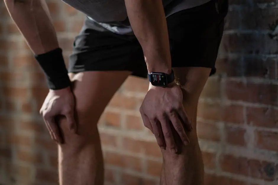 A close-up of an athlete resting after exercise, wearing a digital fitness watch.