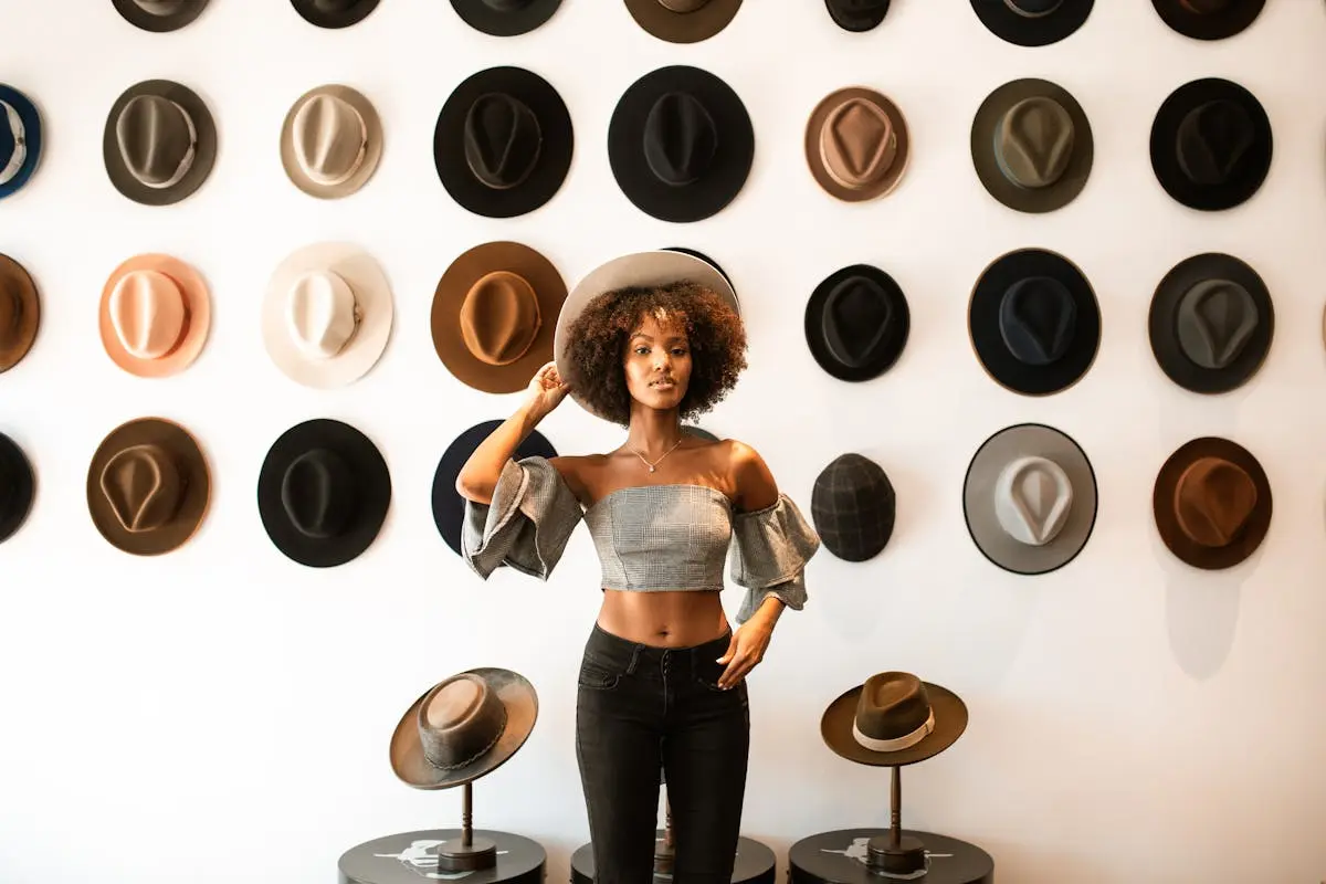 Woman in Gray Tank Top and Black Denim Jeans Wearing a Hat