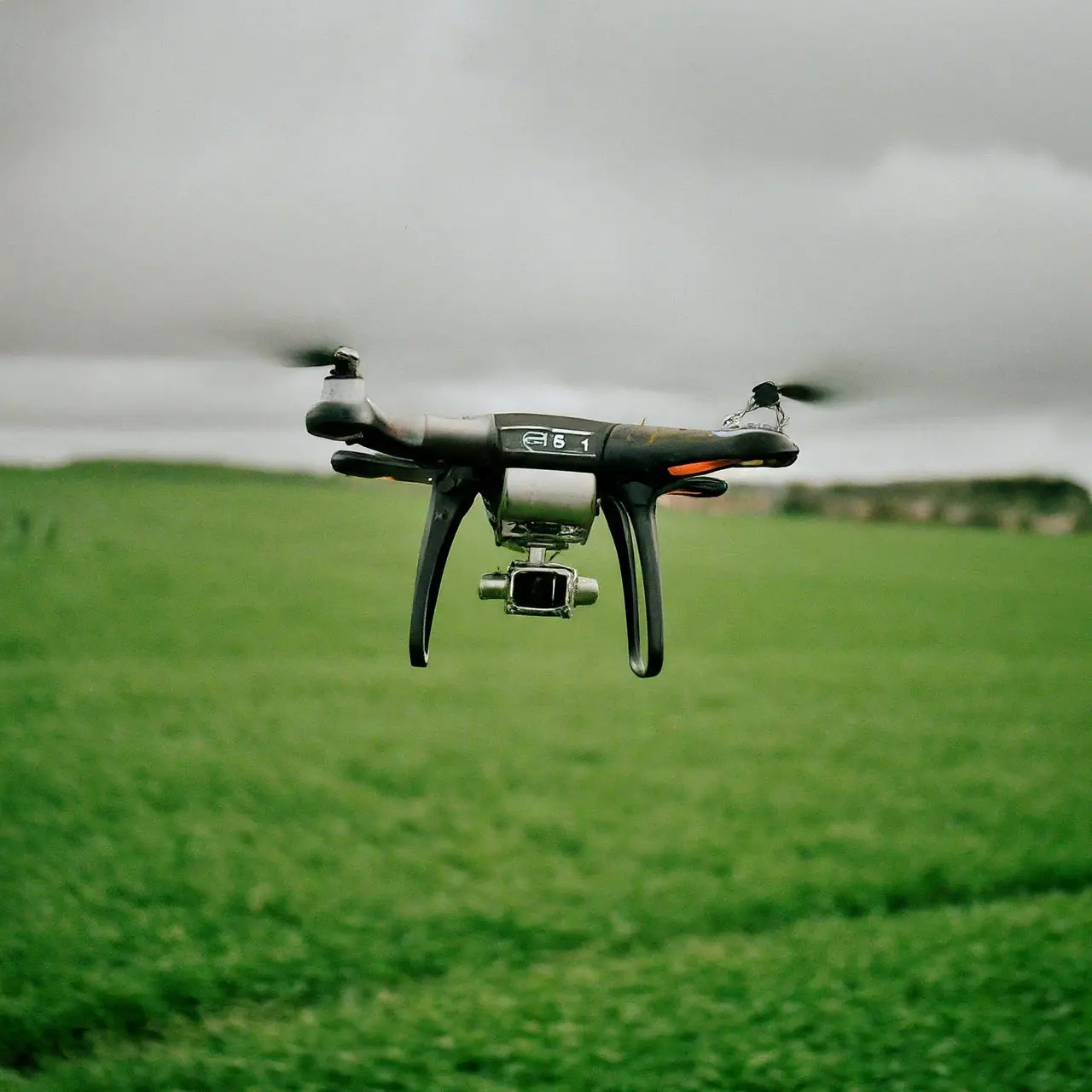 A DJi Agras drone flying over a lush green field. 35mm stock photo