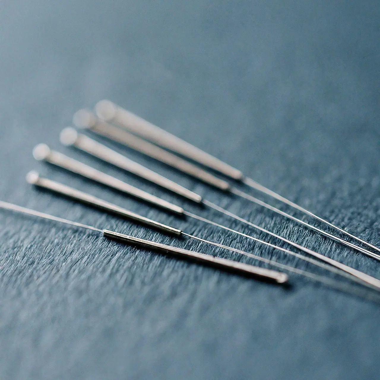 Acupuncture needles arranged neatly on a serene blue background. 35mm stock photo