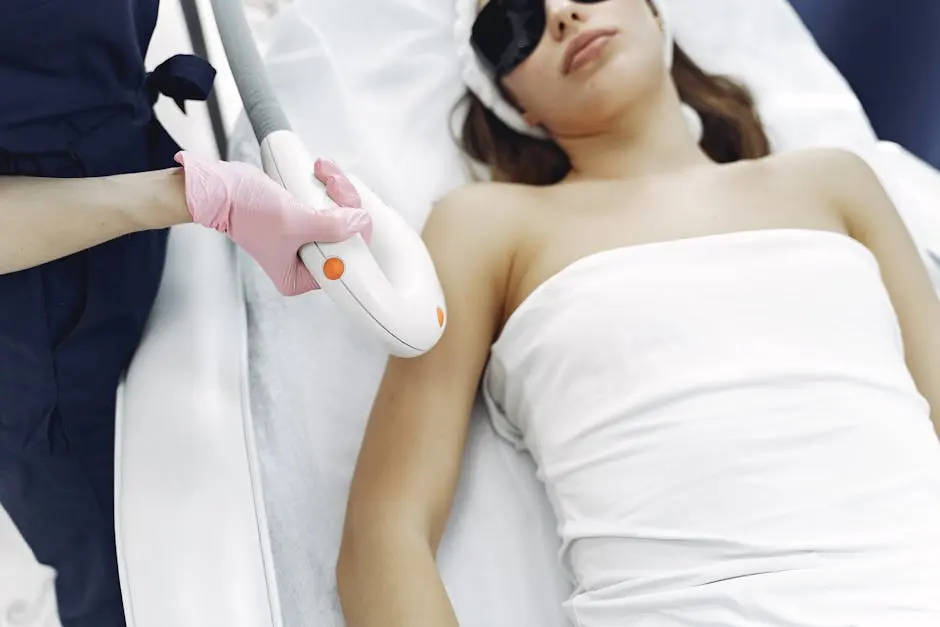 From above of unrecognizable cosmetologist in uniform and latex gloves using modern equipment for cosmetic services in contemporary salon