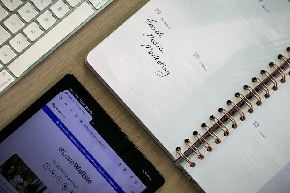 Top view of a notebook, tablet, and keyboard used for social media marketing planning.