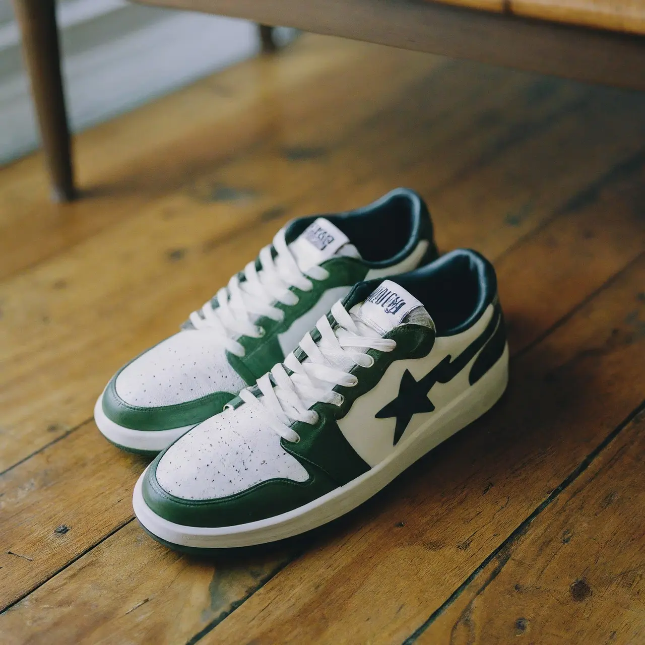 A pair of BAPE sneakers on a wooden floor. 35mm stock photo