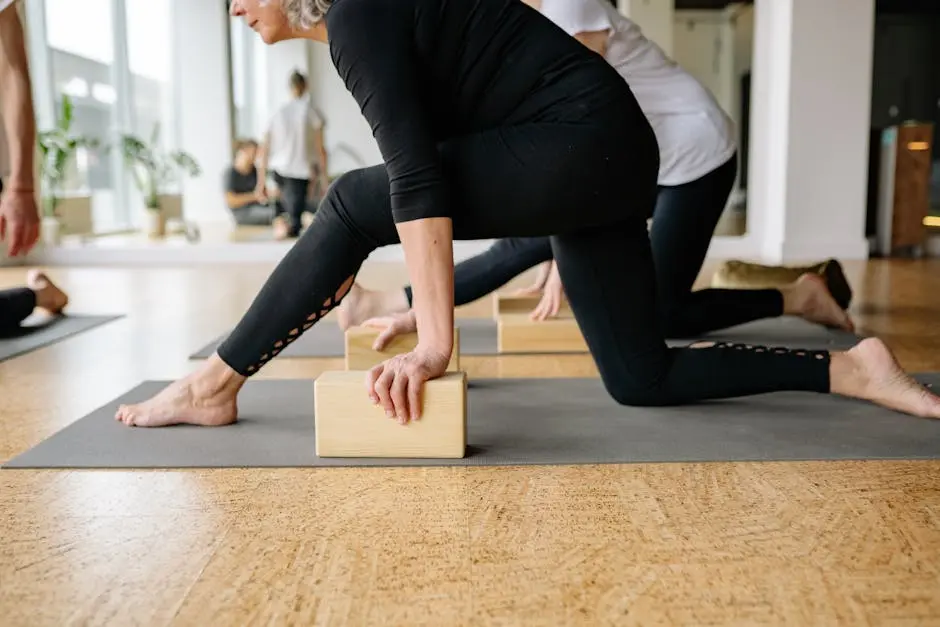 Adults practicing yoga with wooden blocks in a bright studio setting, enhancing flexibility and focus.