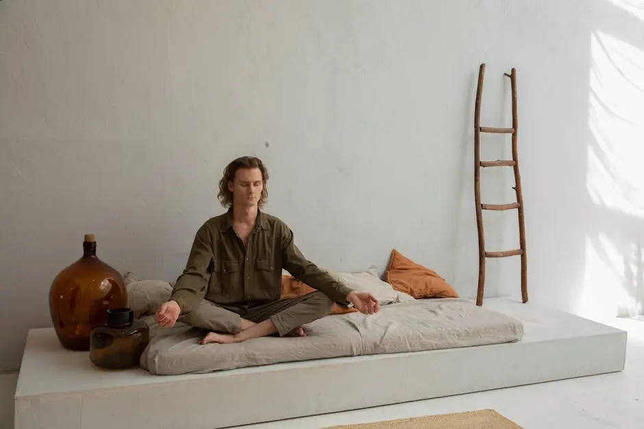 Peaceful man meditating on bed in Lotus pose