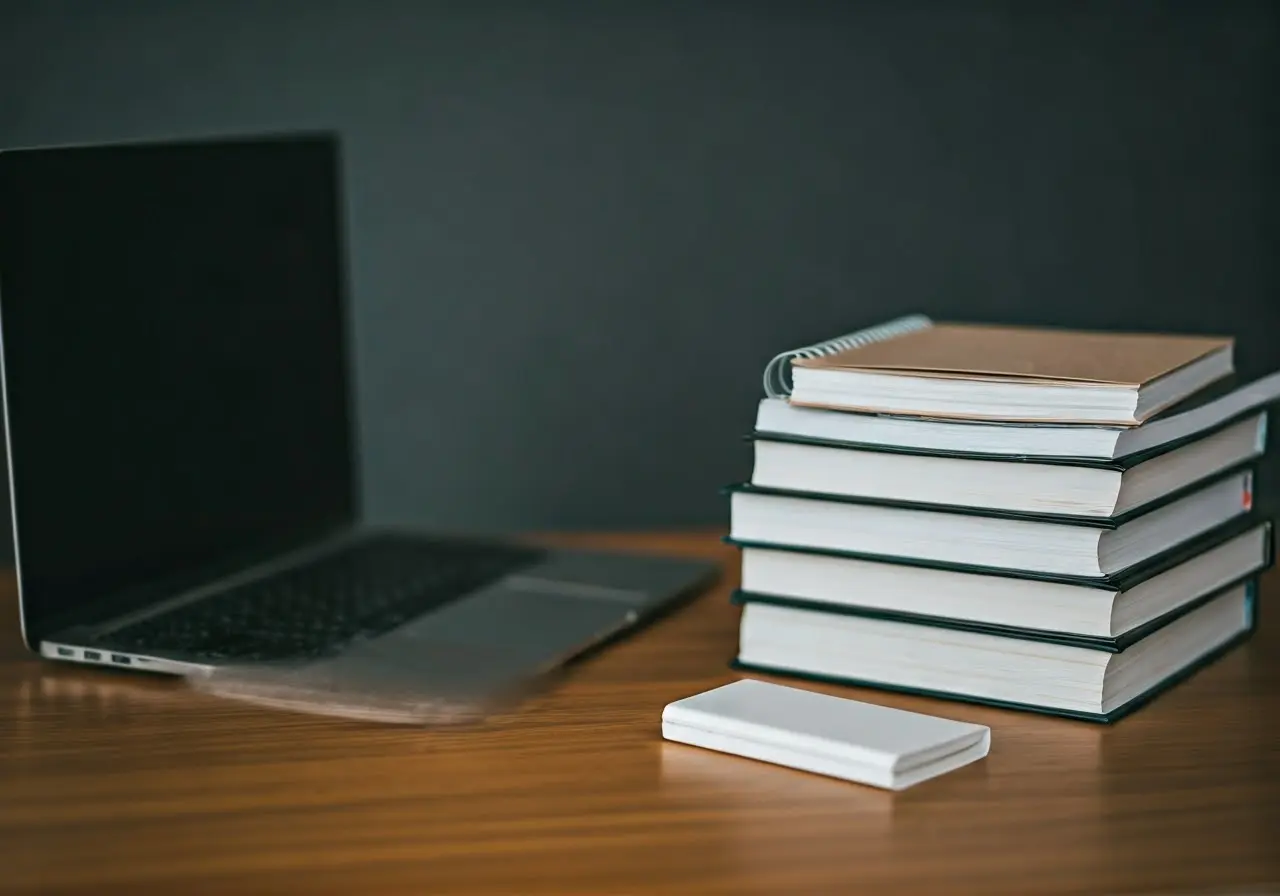 A laptop with a stack of books and a notepad. 35mm stock photo