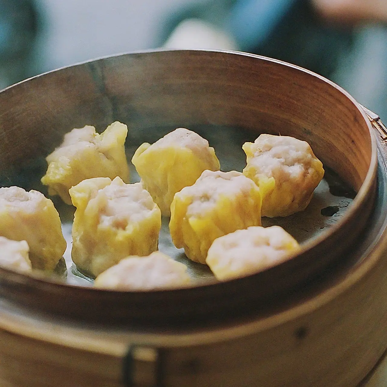 A steaming dim sum basket on a bustling street corner 35mm stock photo