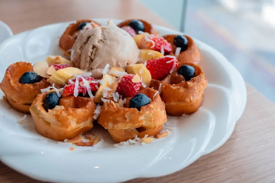 Tasty waffles topped with ice cream and fresh berries, perfect for a sweet breakfast.