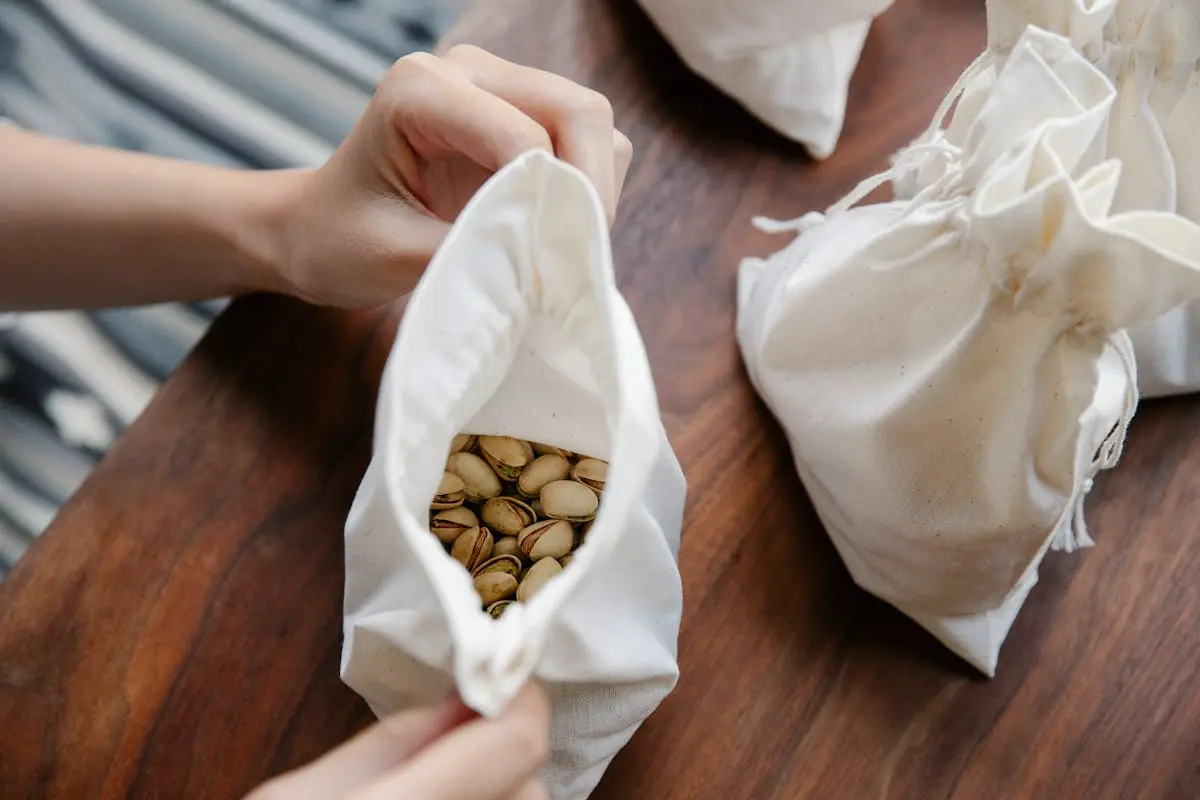 Faceless person demonstrating recycling bag with pistachios