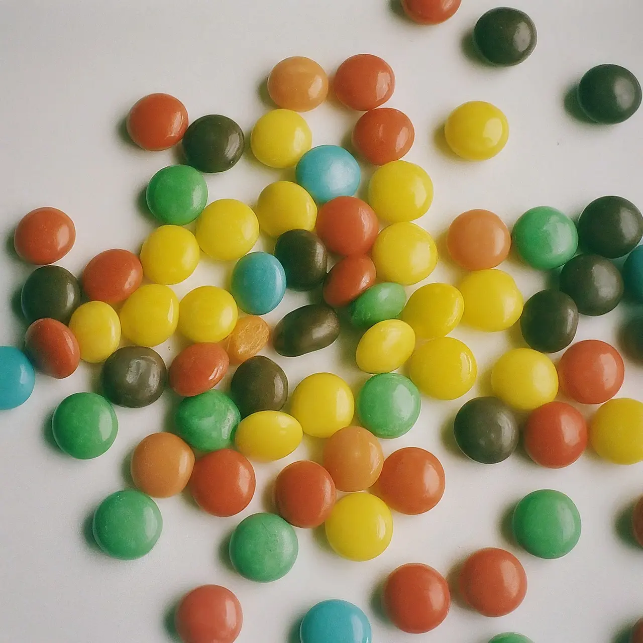 Colorful assorted candies spread out on a white background. 35mm stock photo