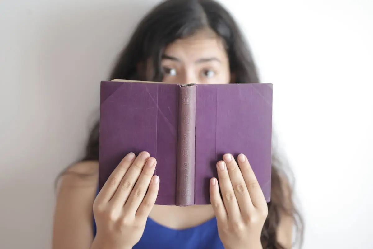 Smart woman with book looking at camera