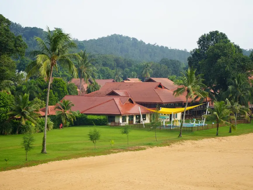 Scenic view of a tropical beachfront resort with lush greenery and palm trees.