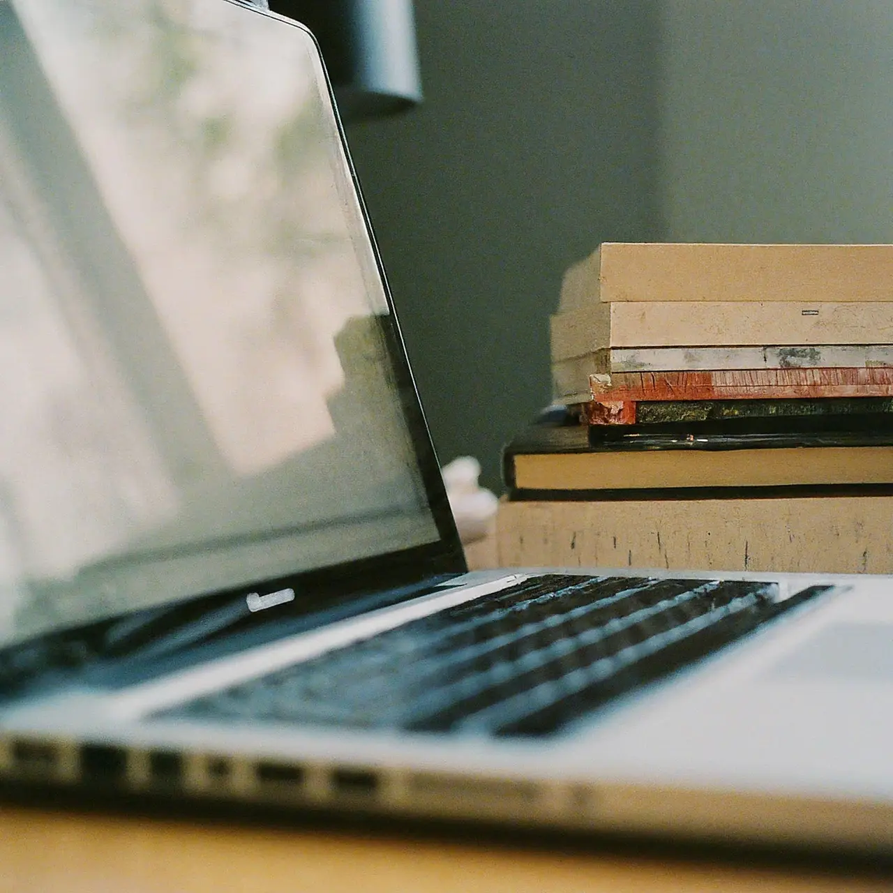 A laptop and textbooks on a desk. 35mm stock photo