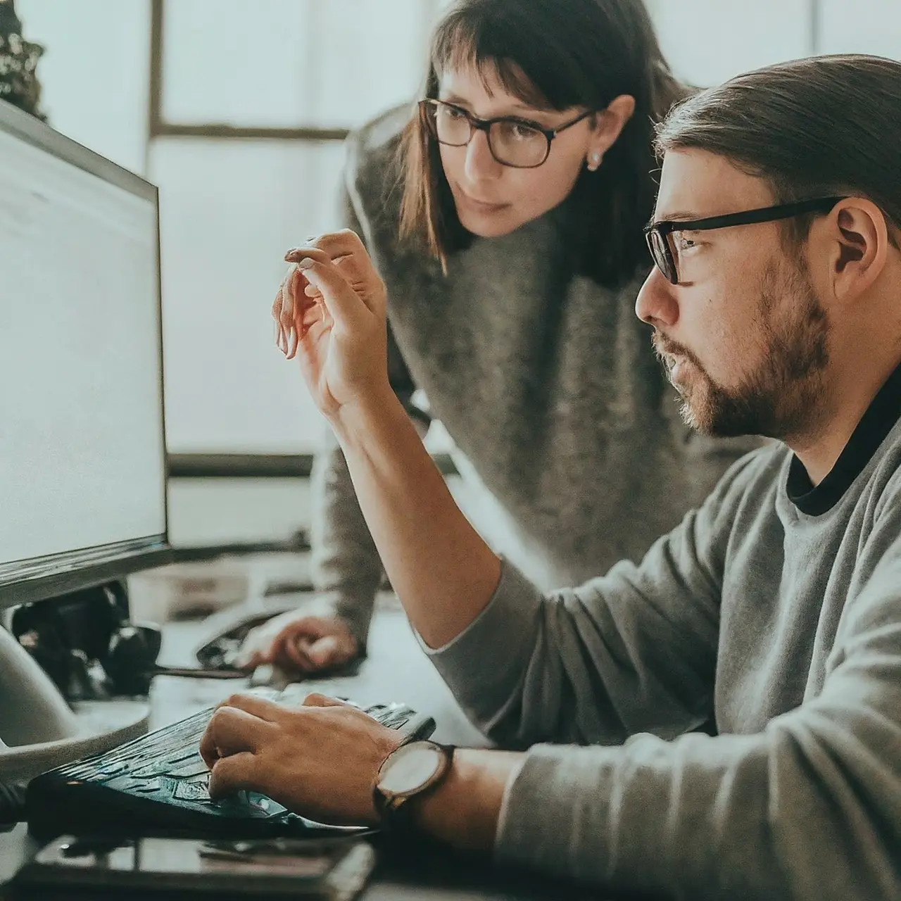 Two workers collaborating on a WordPress project on a computer. 35mm stock photo