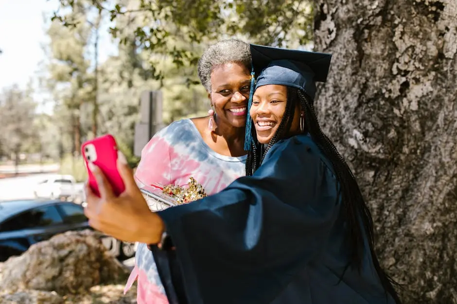 A proud graduate takes a cheerful selfie with family outdoors, capturing a joyful graduation moment.