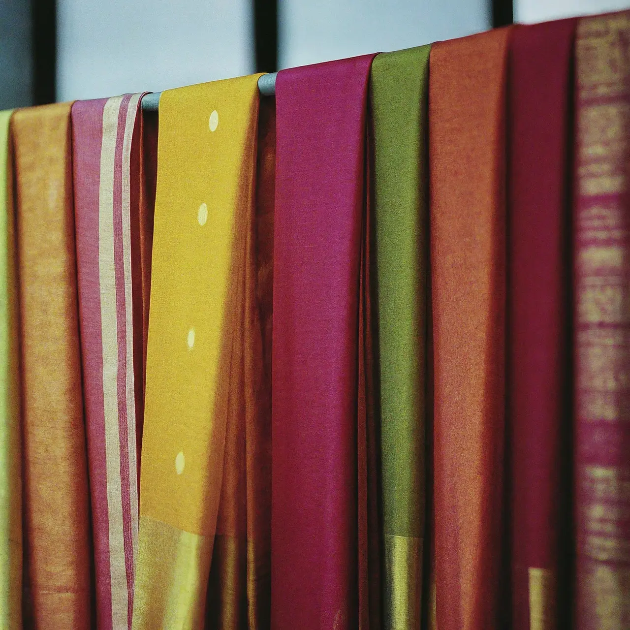 Colorful handloom sarees hanging in a traditional weaving workshop. 35mm stock photo