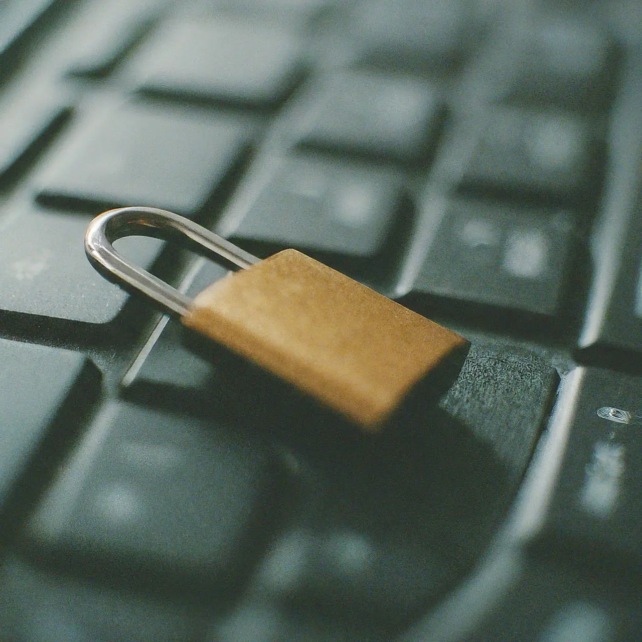 A locked padlock on a computer keyboard. 35mm stock photo