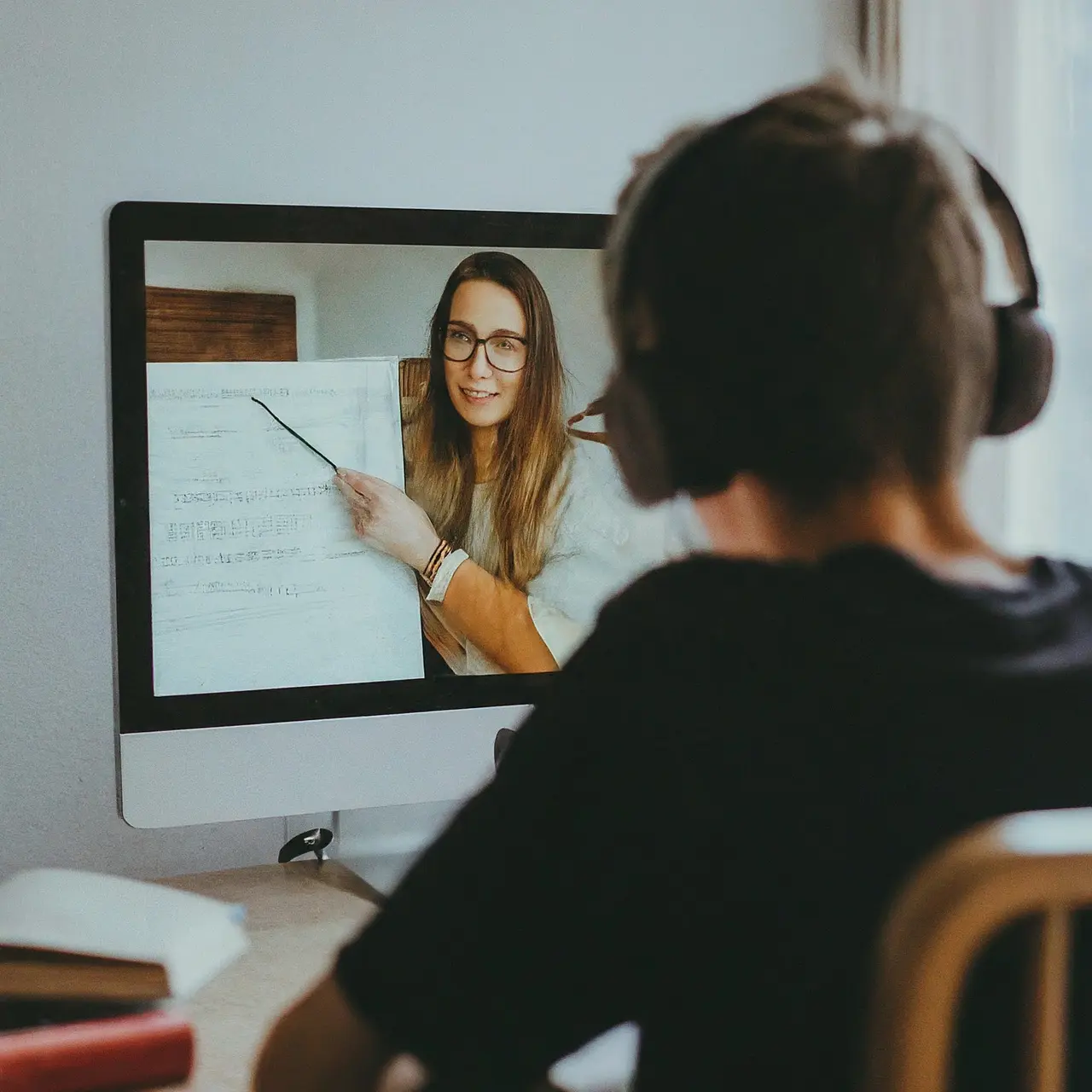 A student studying online with a supportive tutor on screen. 35mm stock photo