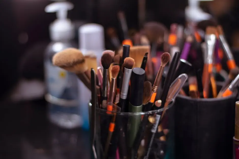 Close-up of assorted makeup brushes in a glass jar, showcasing a variety of textures and colors.