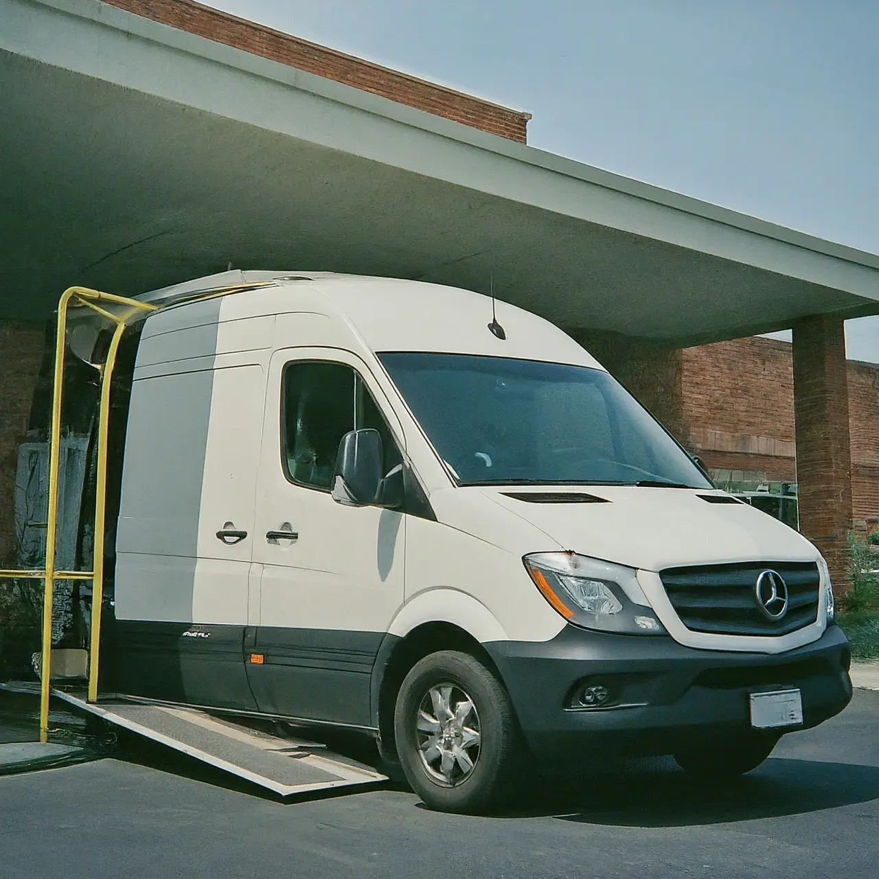 Wheelchair-accessible van with ramp extended at a hospital entrance. 35mm stock photo