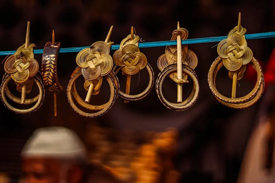 Close-up of intricately woven bamboo jewelry hanging on a line with blurred background.