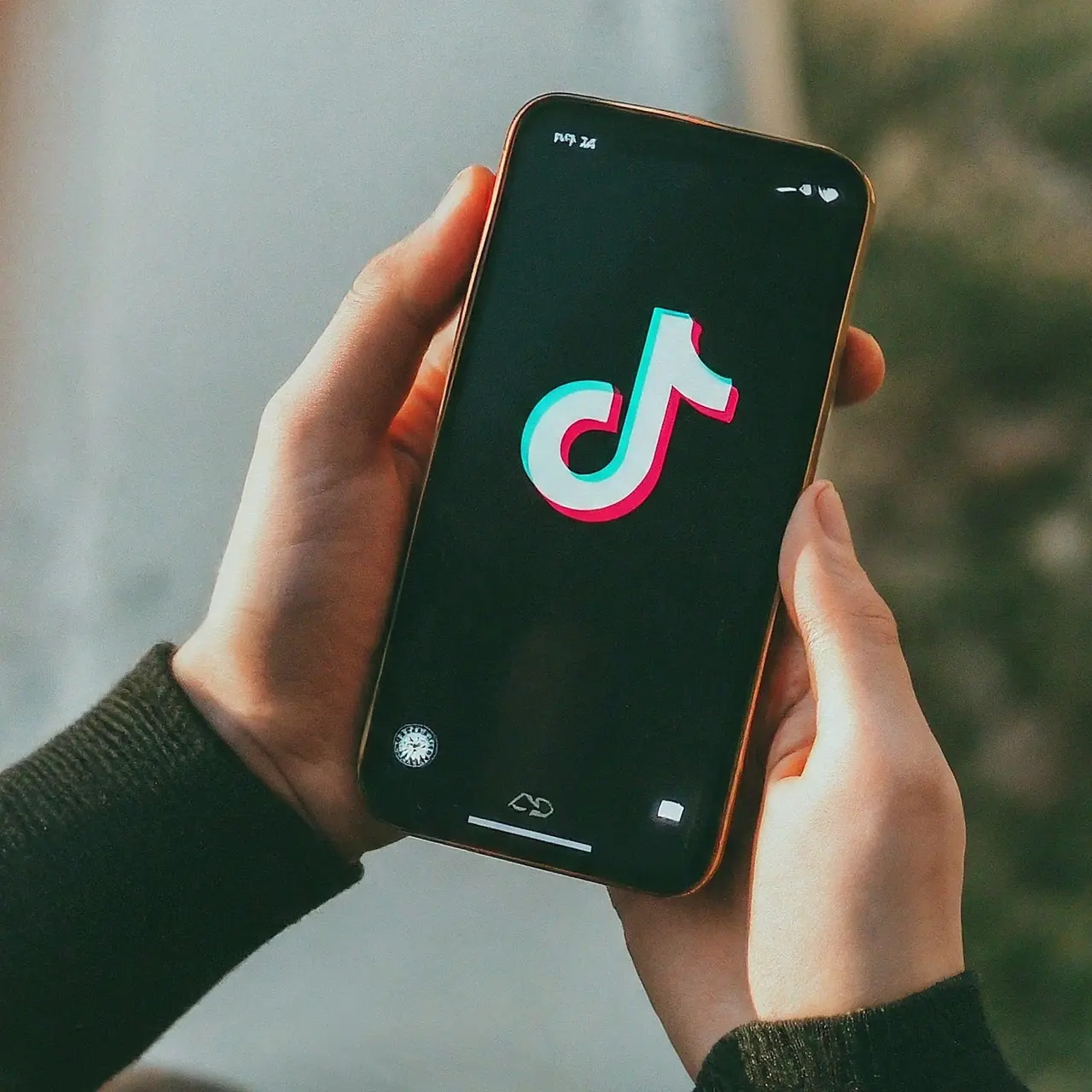 Une personne tenant un smartphone avec l’icône TikTok visible. 35mm stock photo