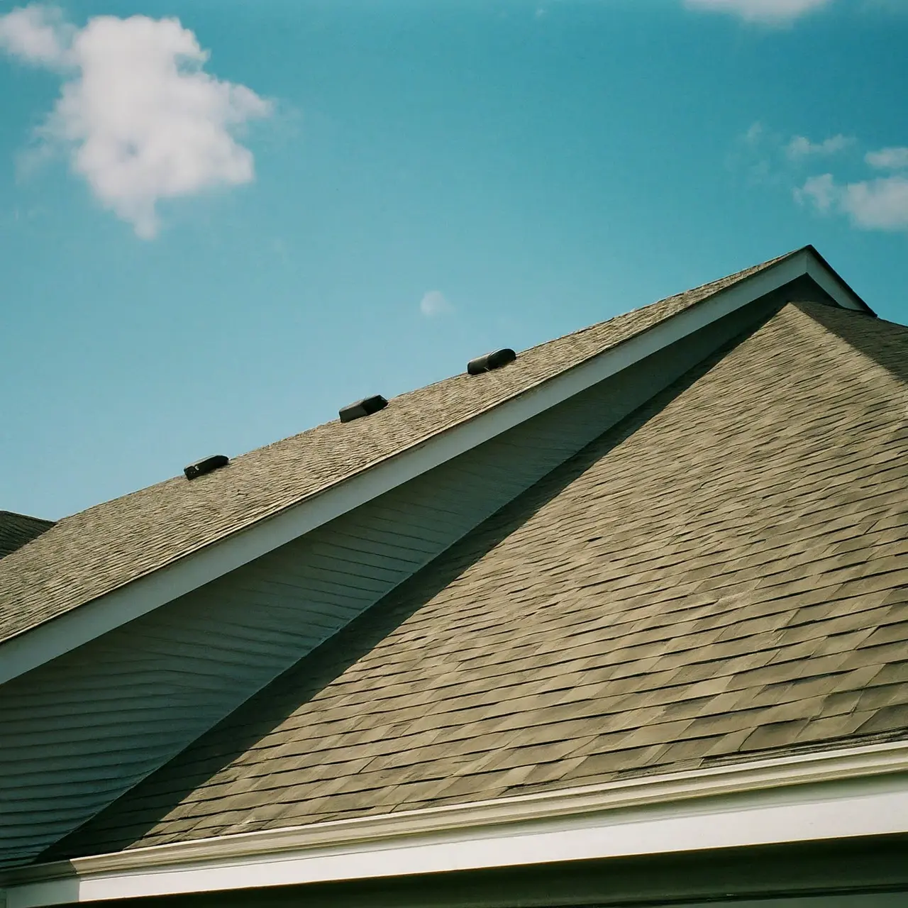 A pristine roof on a suburban home under a sunny sky. 35mm stock photo