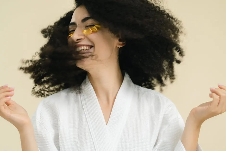 Young Woman in a Bathrobe Wearing Under Eye Patches and Smiling