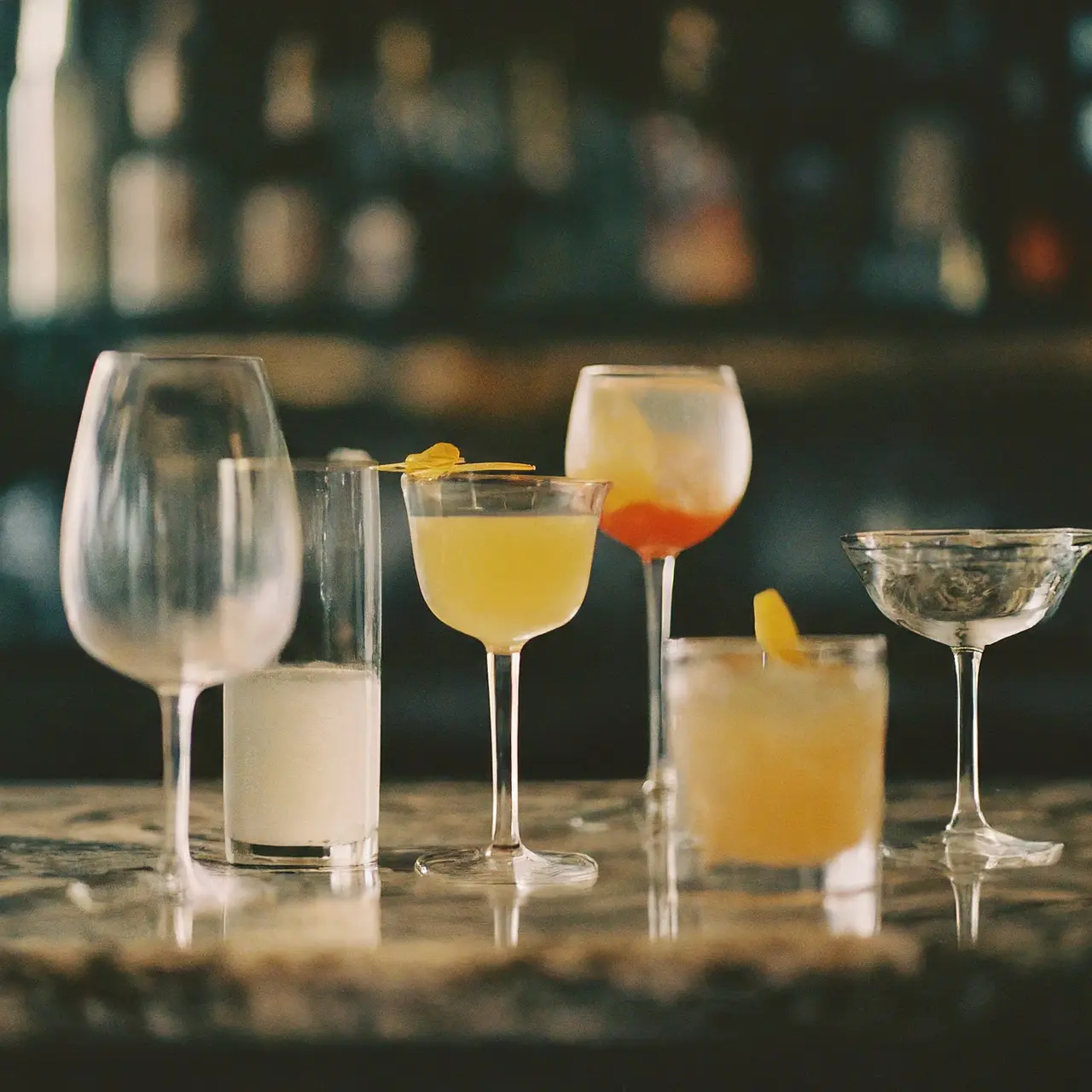 Various types of cocktail glasses arranged on a marble bar. 35mm stock photo