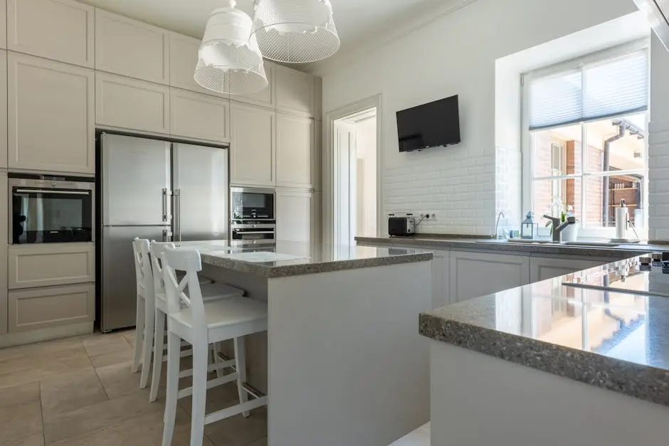 Spacious kitchen interior featuring granite countertops, stainless steel appliances, and a bright atmosphere.