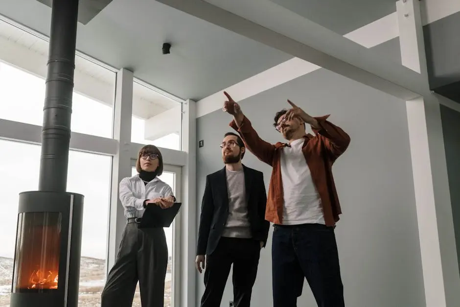 A group of professionals discussing interior design plans in a modern building with large windows and a fireplace.