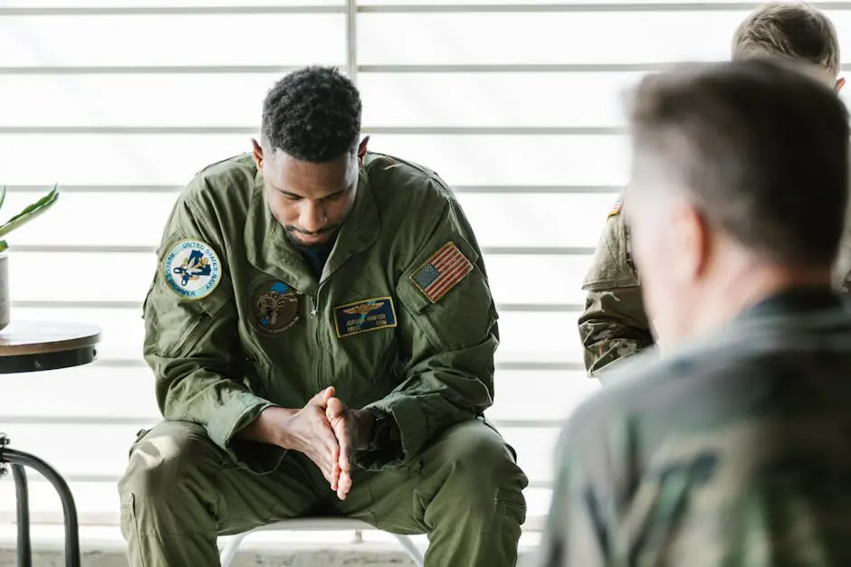 A soldier dressed in uniform sits pensively during a counseling session, embodying themes of mental health and support.