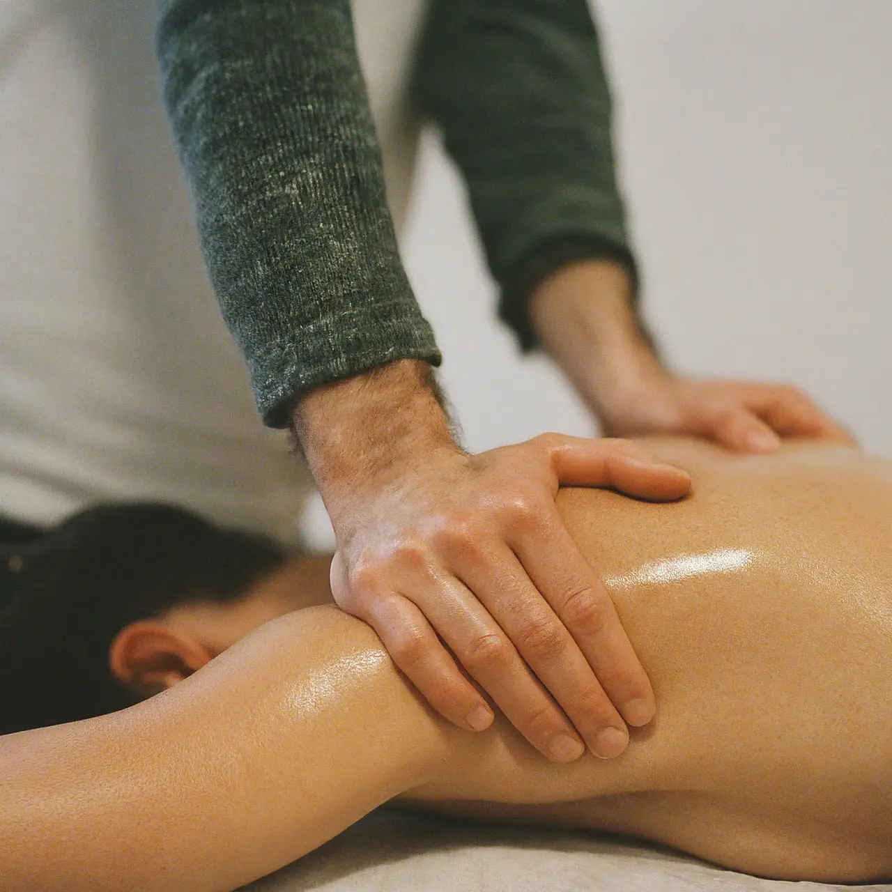 Close-up of hands performing therapeutic massage on a muscular back. 35mm stock photo