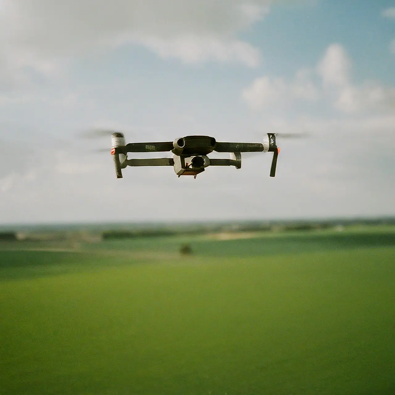 DJI Agras T40 drone flying over green farmland. 35mm stock photo