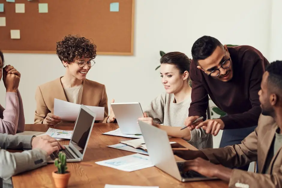 A diverse group of professionals engaged in a collaborative office meeting, sharing ideas and discussing projects.