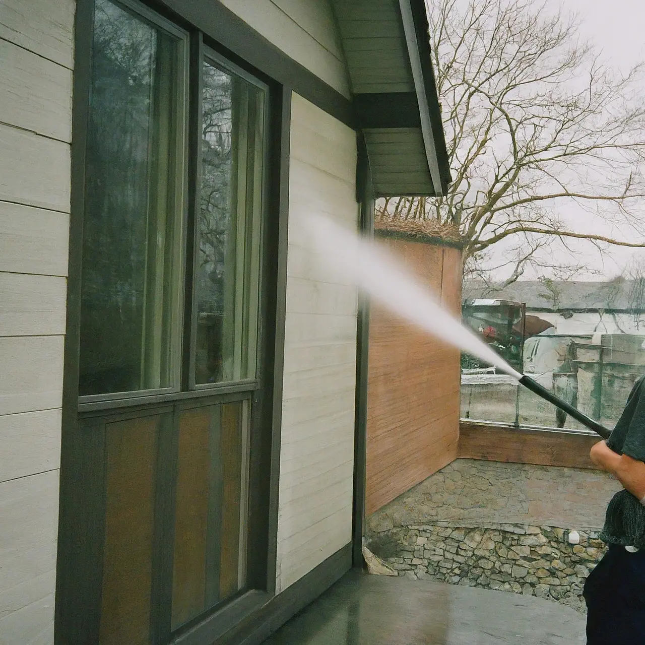 A pressure washer cleaning a house’s exterior. 35mm stock photo