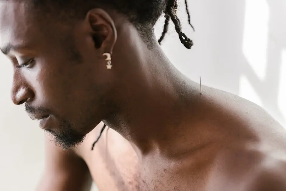 A close-up view of acupuncture needle on a man’s shoulder, highlighting alternative therapy.