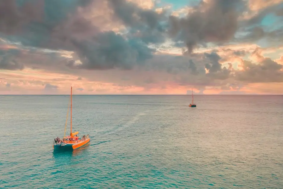 Sailboats cruising during a vibrant sunset, capturing a peaceful ocean expanse.