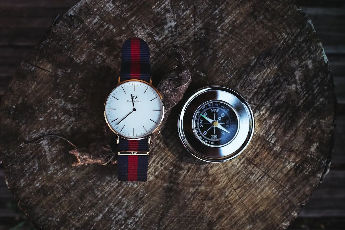 Round Silver-colored Analog Watch Beside Compass