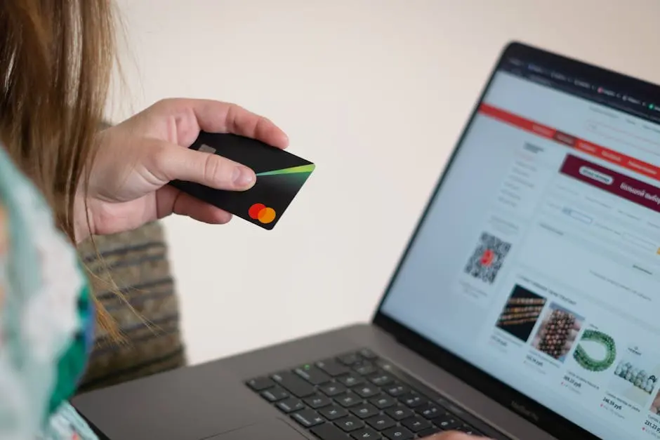 Woman holding credit card while shopping online, showcasing e-commerce convenience.