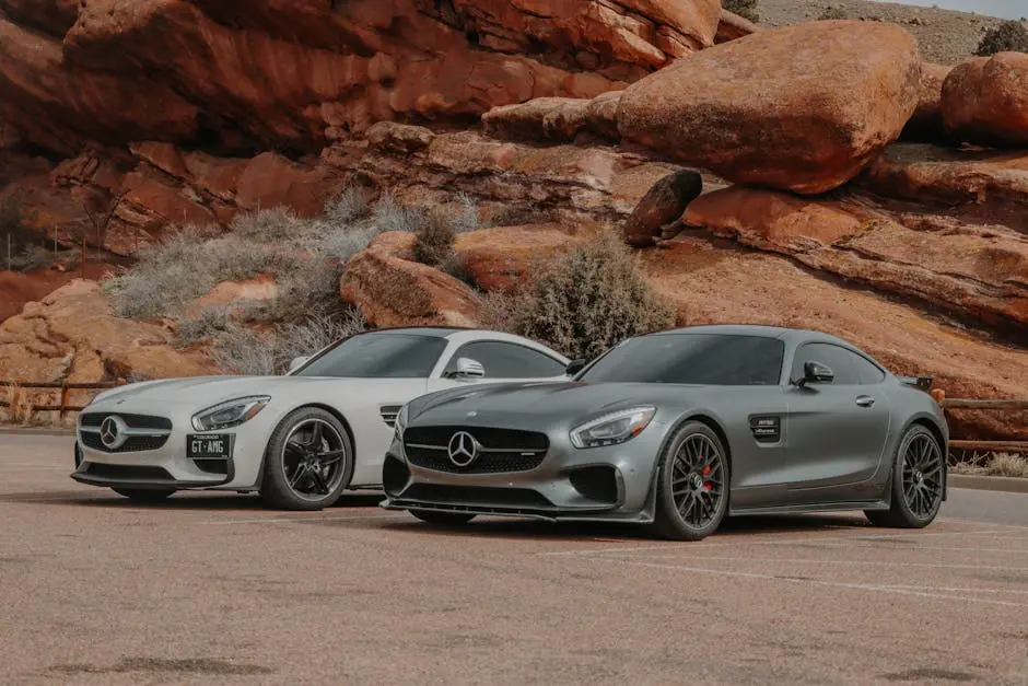 Two Mercedes-Benz AMG GT sports cars parked against a stunning rock backdrop, showcasing luxury and style.