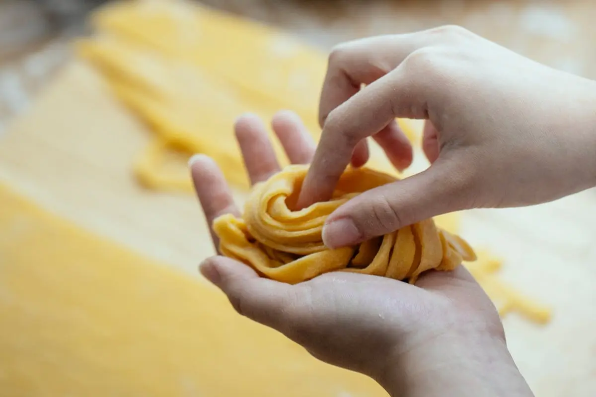 Woman making homemade pasta with egg dough