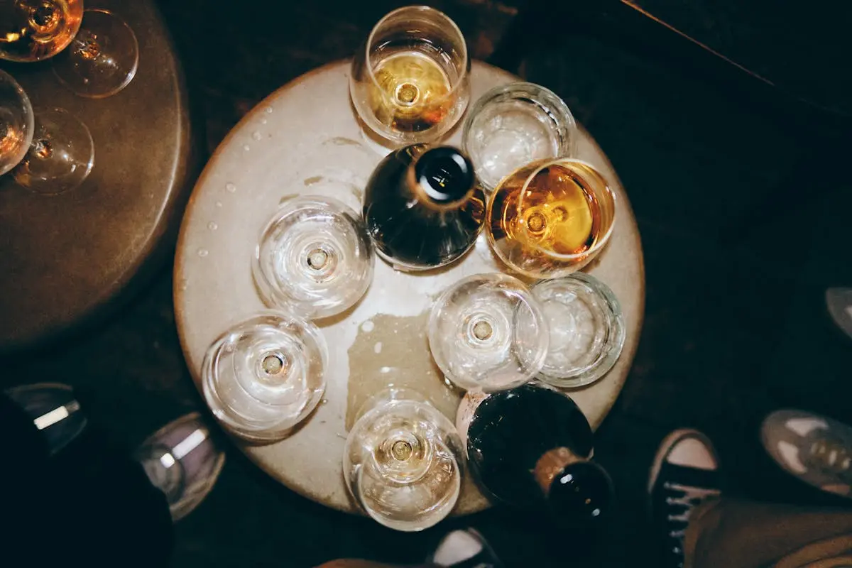 Aerial shot of various glasses with drinks on a round table, ideal for nightlife themes.