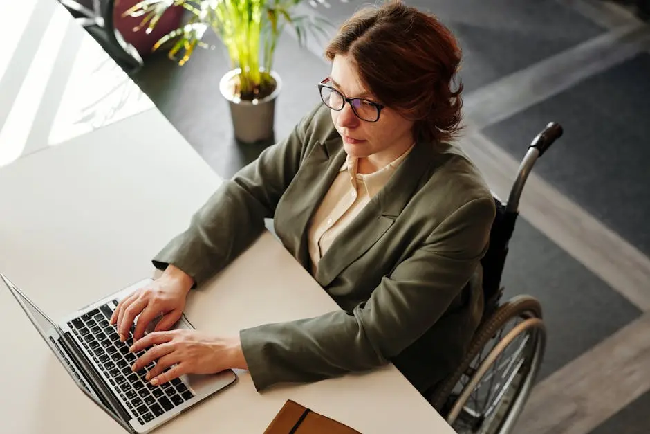 A Woman Sitting on the Wheelchair While using Laptop