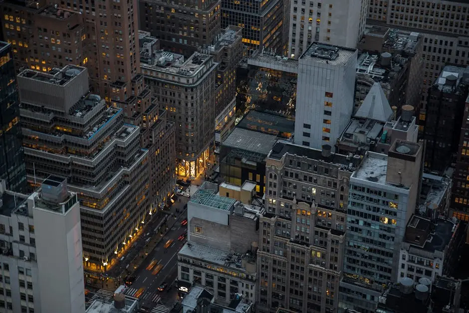 A dramatic aerial view of illuminated skyscrapers in Manhattan, New York City, showcasing urban architecture and city life at night.