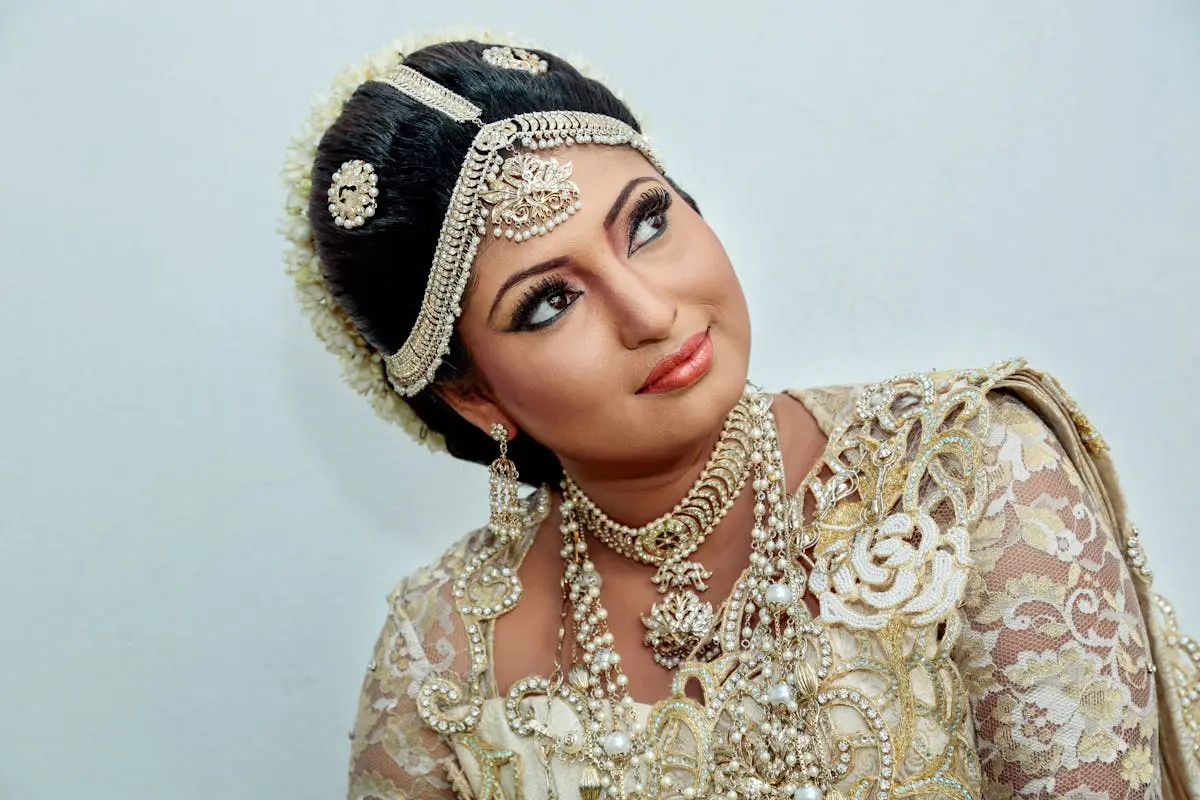 A stunning portrait of a South Asian bride in luxurious traditional attire adorned with intricate jewelry and floral lace.