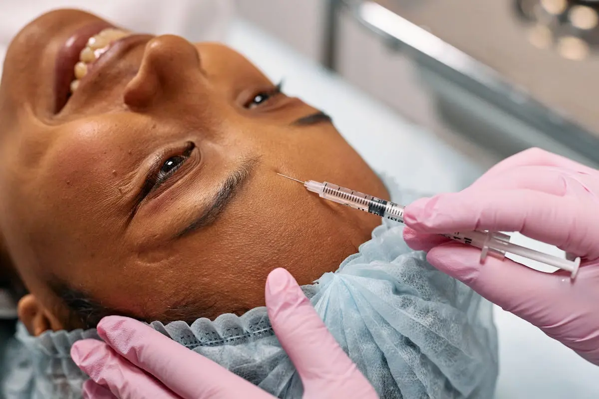 Close-up of a woman receiving a cosmetic injection on her forehead in a clinical setting.