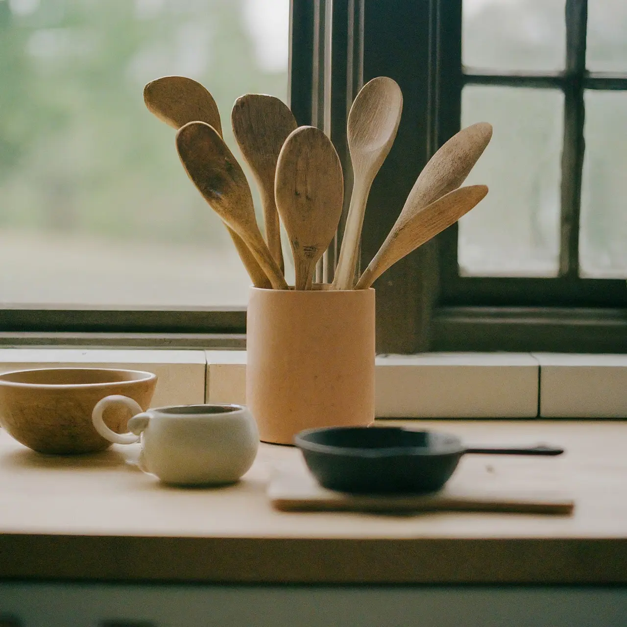 Assorted kitchen utensils and cookware on a wooden counter. 35mm stock photo