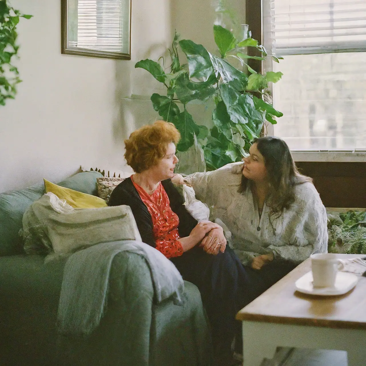 A hospice social worker comforting a family in a cozy living room. 35mm stock photo