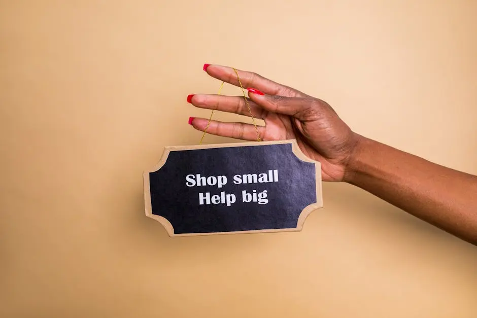 Close-up of a hand holding an inspiring sign encouraging small businesses support.